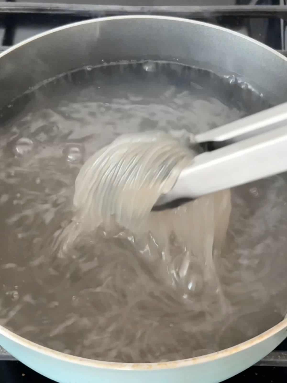 Glass noodles boiling in a pot of water. 