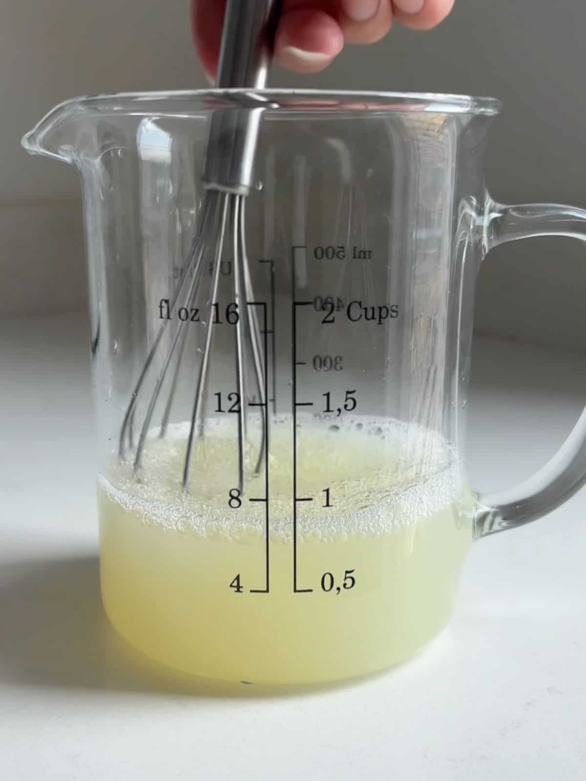 Whisking egg whites, salt and water in a measuring cup.