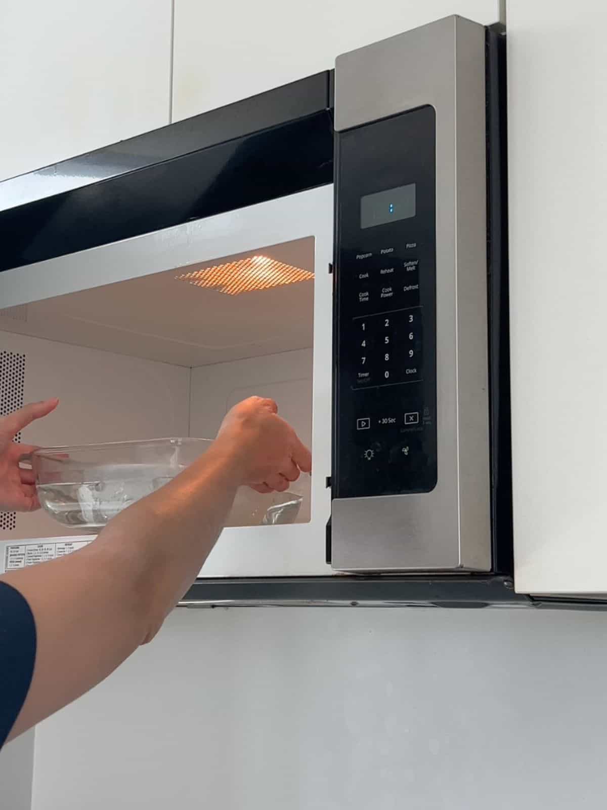 Placing the egg whites in a water bath and into the microwave.