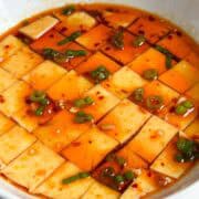 microwaved steamed eggs cut into squares topped with scallions, chili oil, sesame oil and soy sauce.