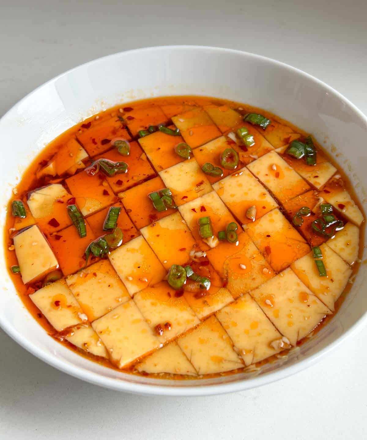 microwaved steamed eggs cut into squares topped with scallions, chili oil, sesame oil and soy sauce.