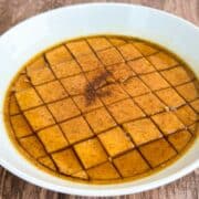 pumpkin flan cut into squares with pumpkin spice and brown sugar syrup.