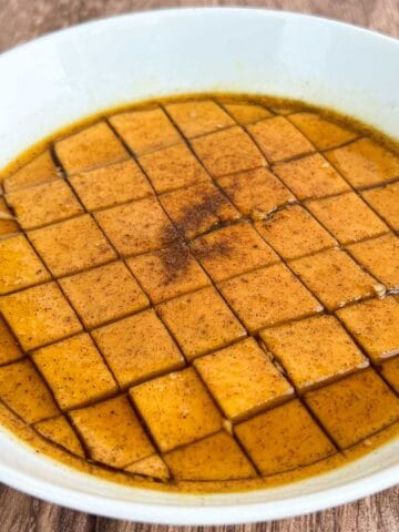 pumpkin flan cut into squares with pumpkin spice and brown sugar syrup.