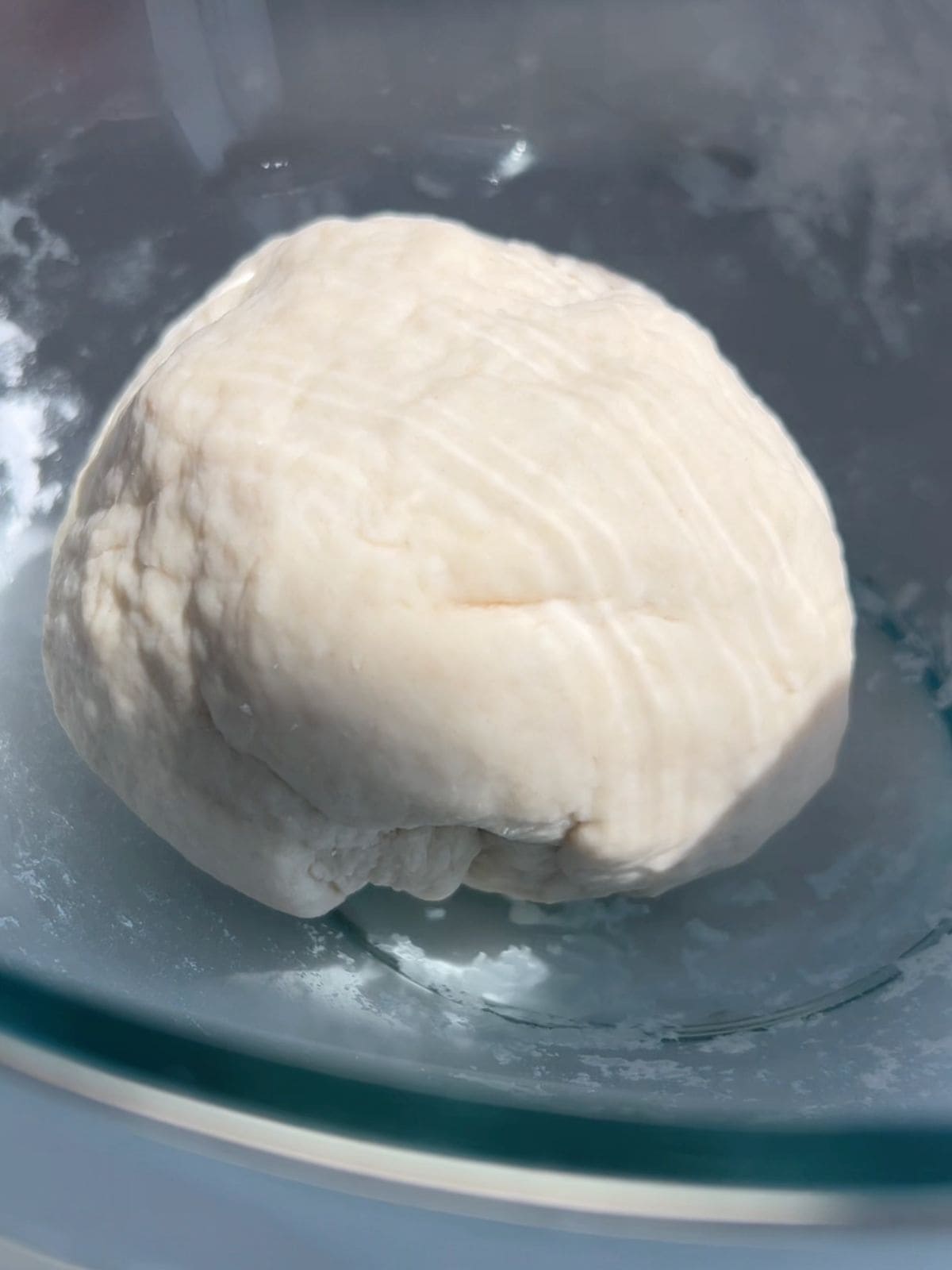 Dough for scallion pancakes in a glass mixing bowl.