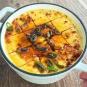 steamed eggs in pot with scallions, sesame oil, soy sauce, and chili oil.