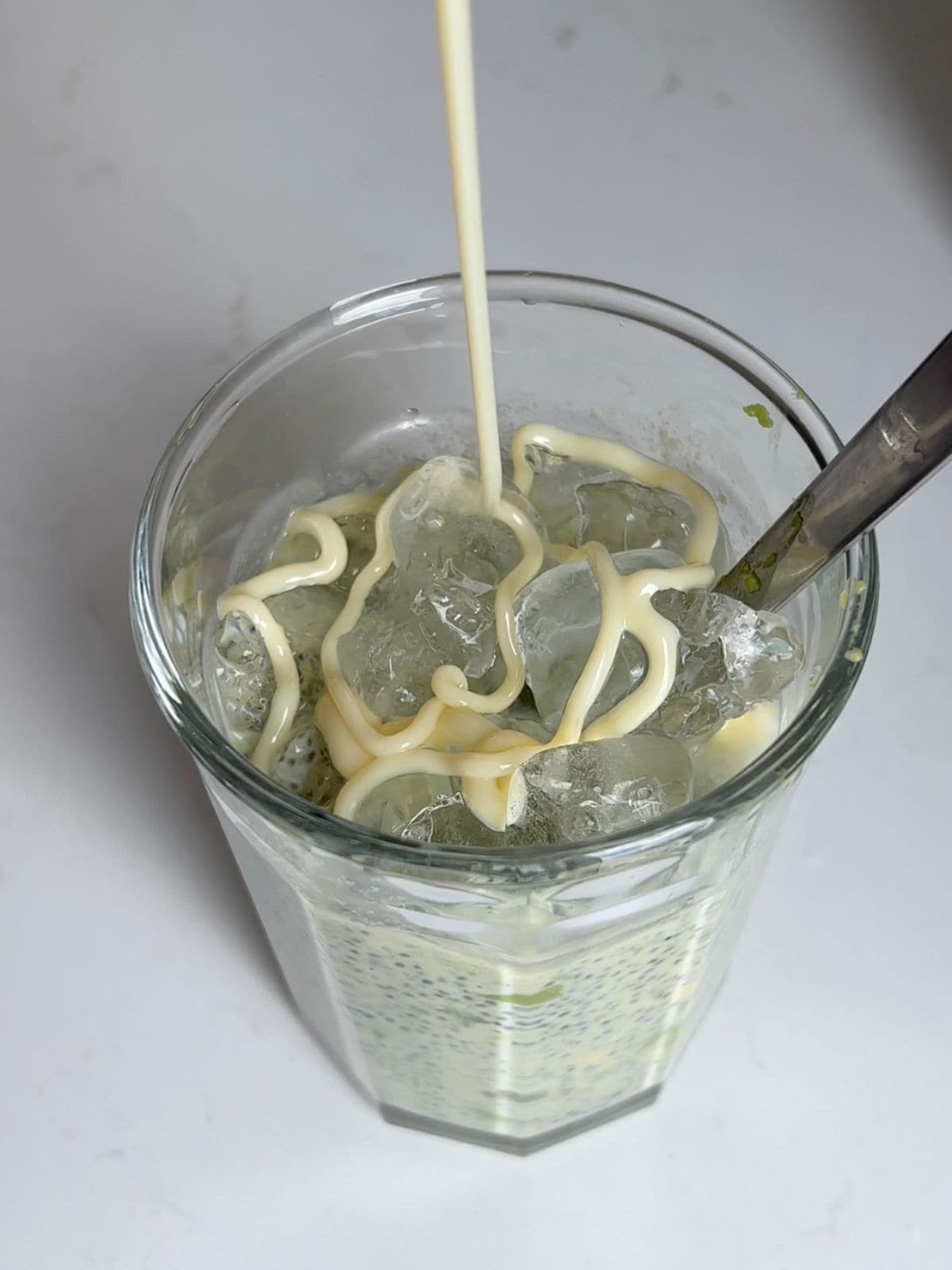 Pouring condensed milk into the pudding with crushed ice.