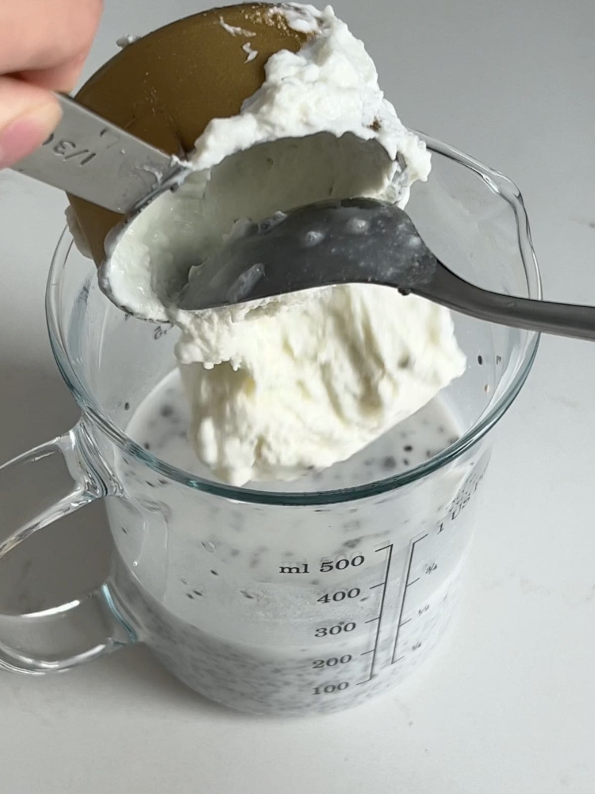 Adding Greek yogurt to the milk and chia mixture.