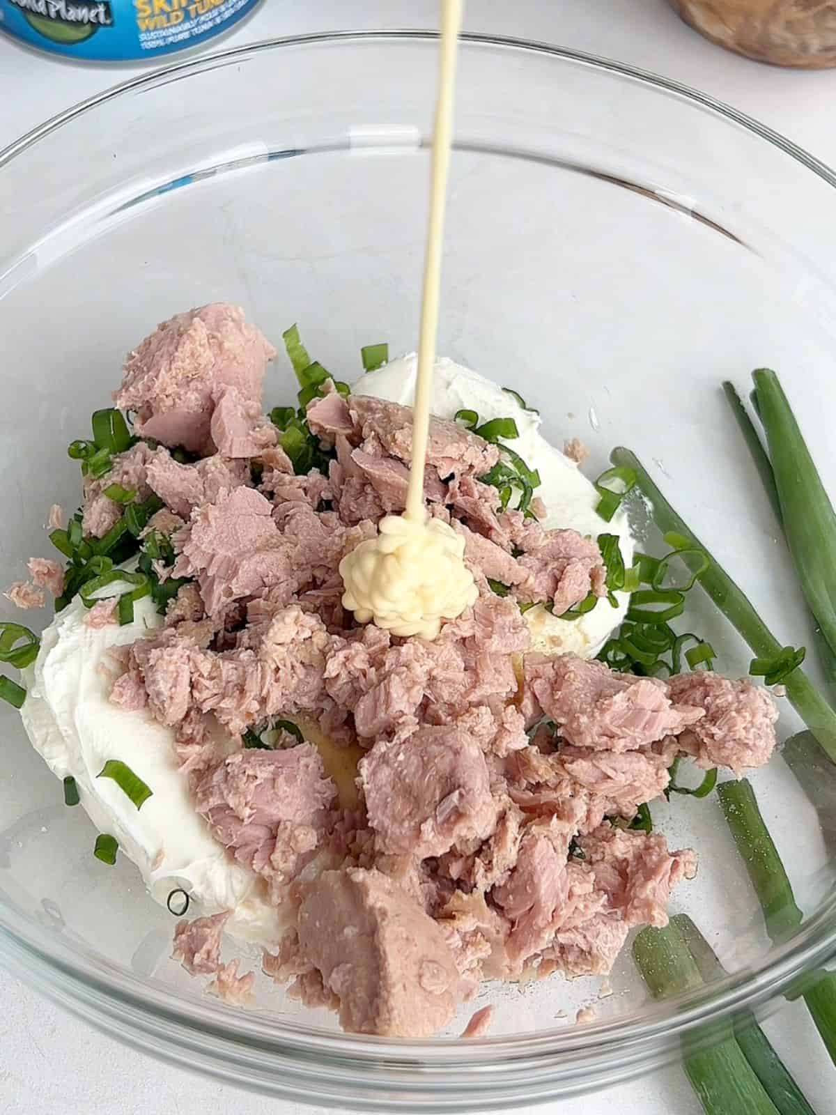 Ingredients needed for the filling of tuna cream cheese wontons in a glass mixing bowl.