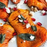 Overhead shot of brown butter butternut squash topped with sage, boursin cheese, and pomegranate seeds.