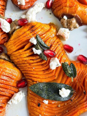 Overhead shot of brown butter butternut squash topped with sage, boursin cheese, and pomegranate seeds.