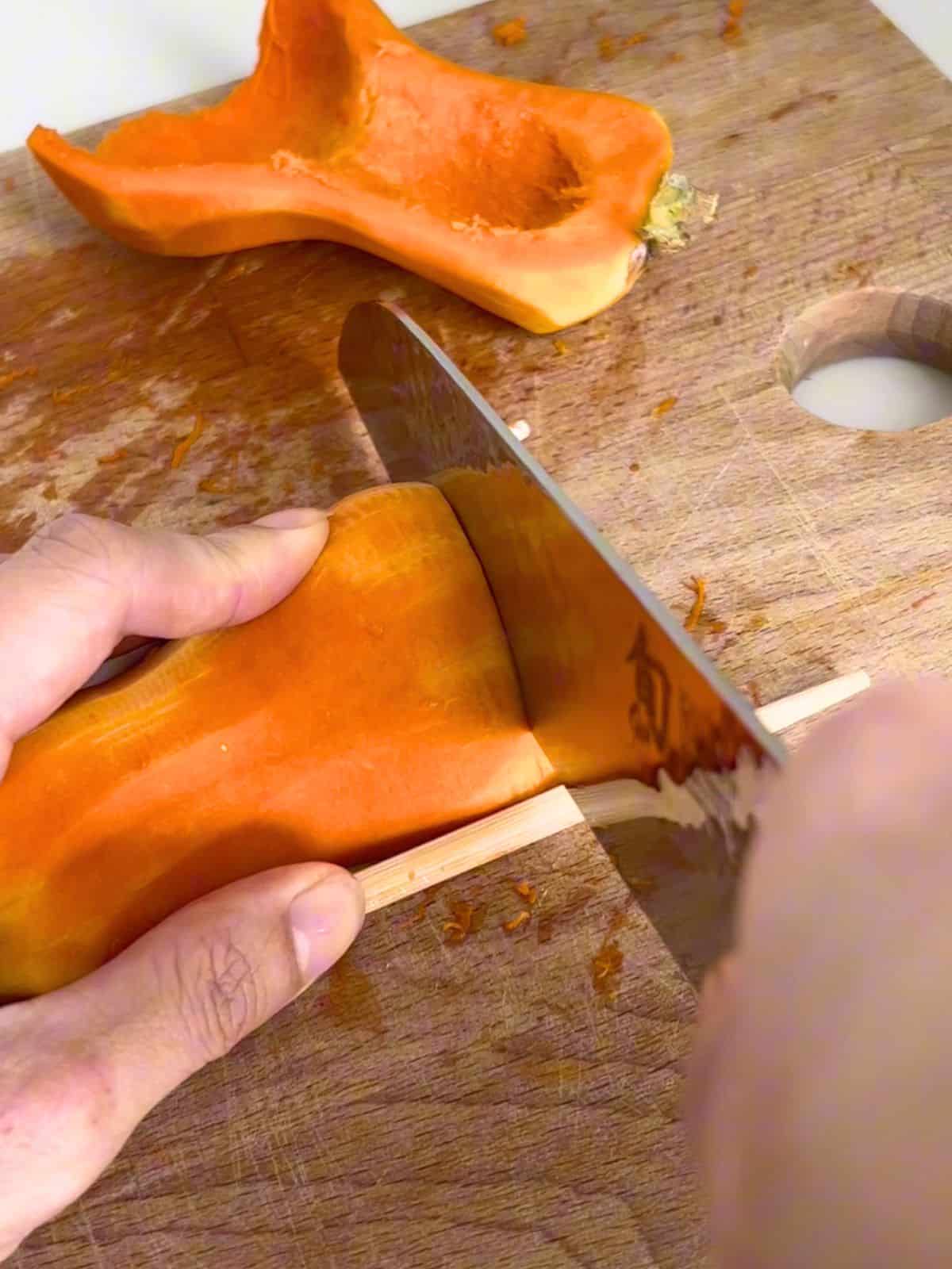 Slicing the honeynut squash on a butting board.