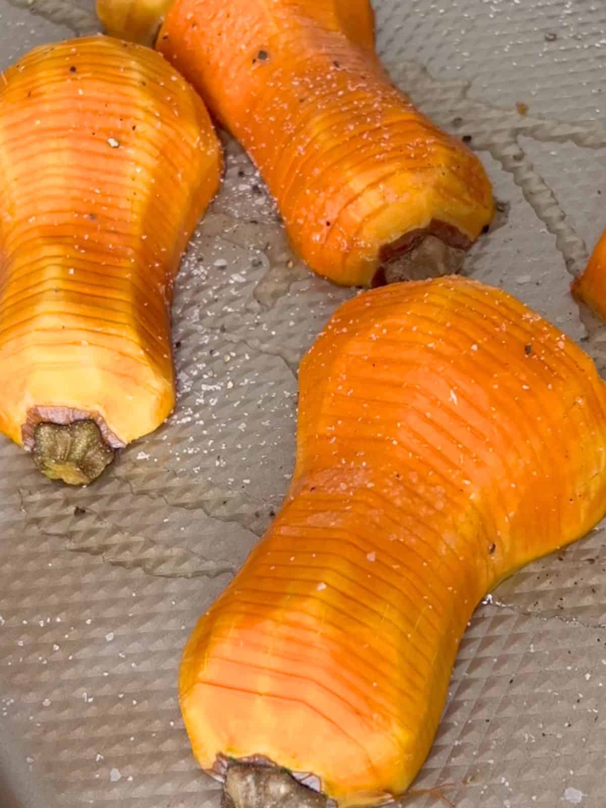 Honeynut squash ready to go into the oven after being sliced and seasoned.