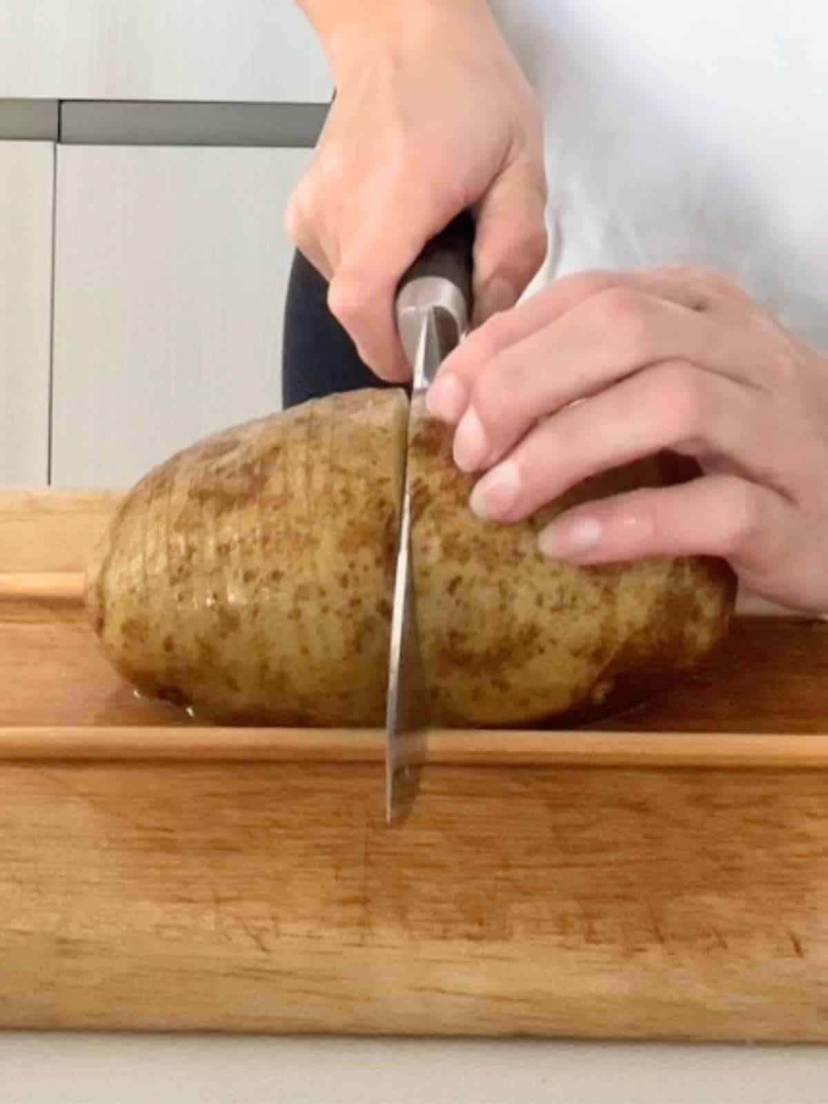 Using a sharp knife to slice the potatoes.