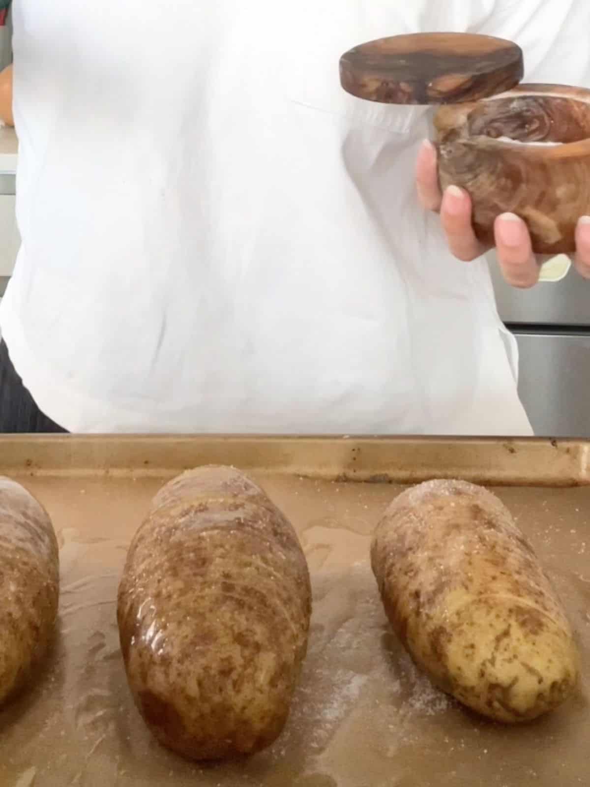 Sprinkling salt on the sliced hasselback potatoes before baking them.