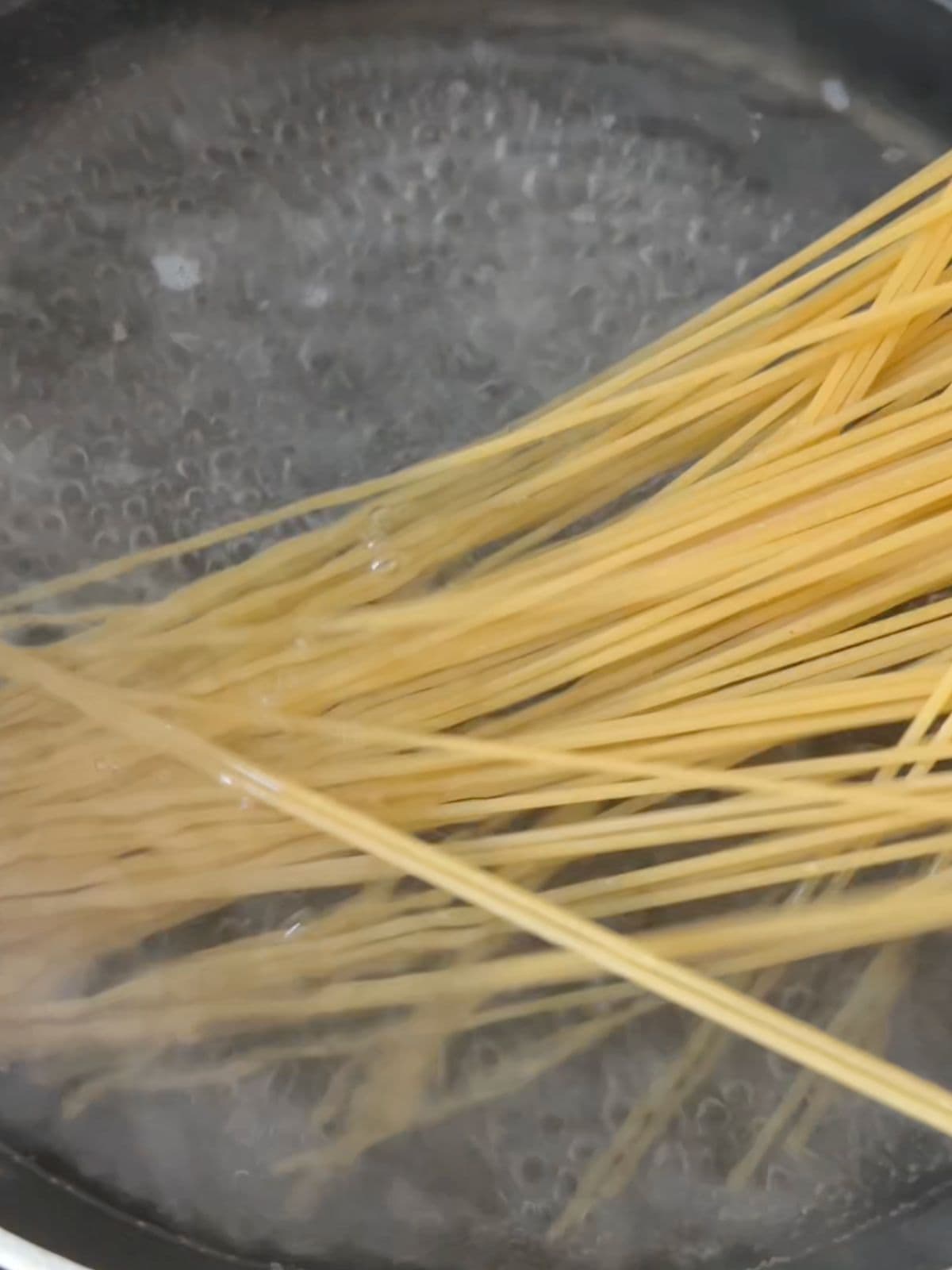 Cooking spaghetti in a pot of boiling water.