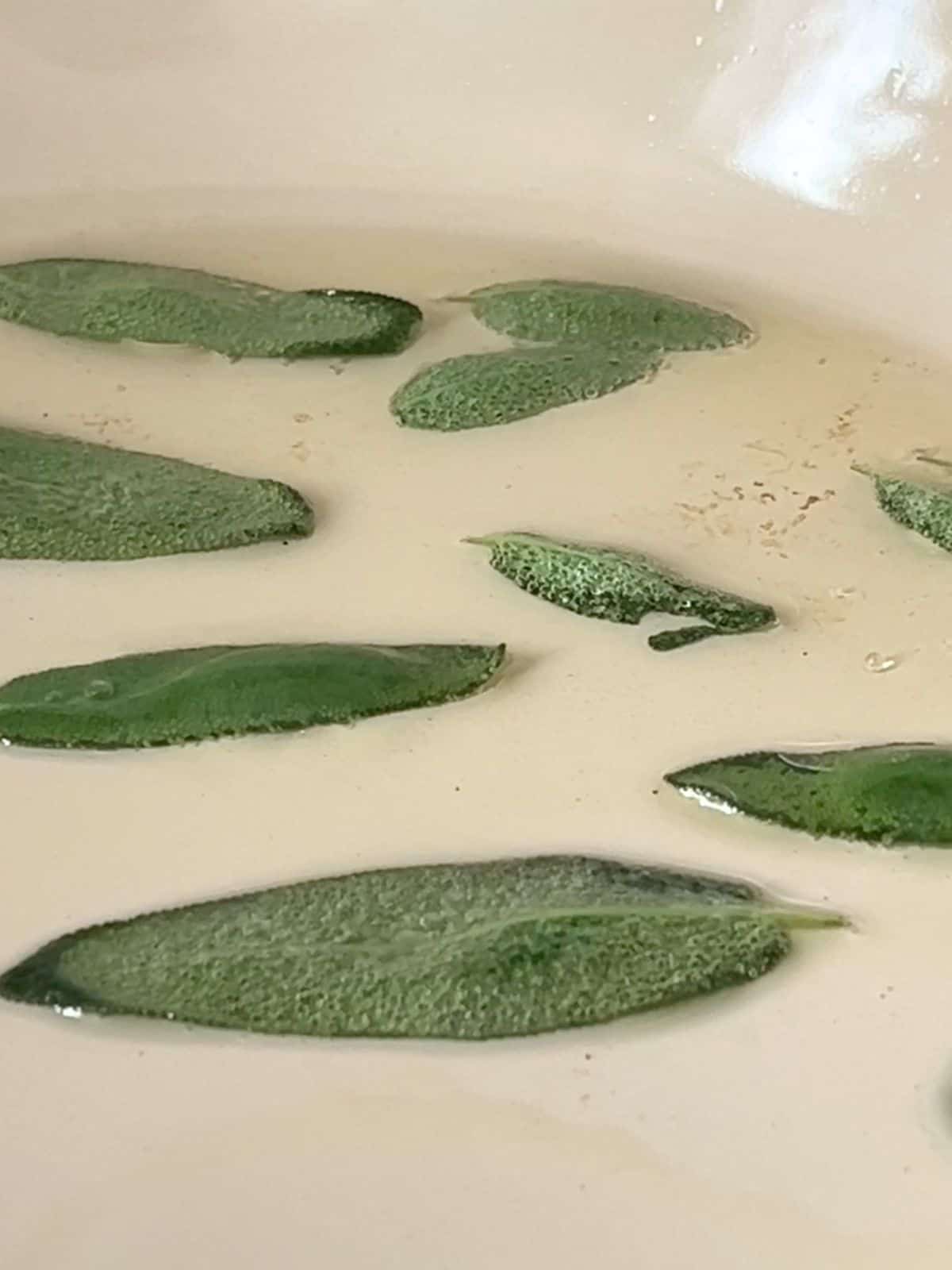 Frying sage leaves in a pan.