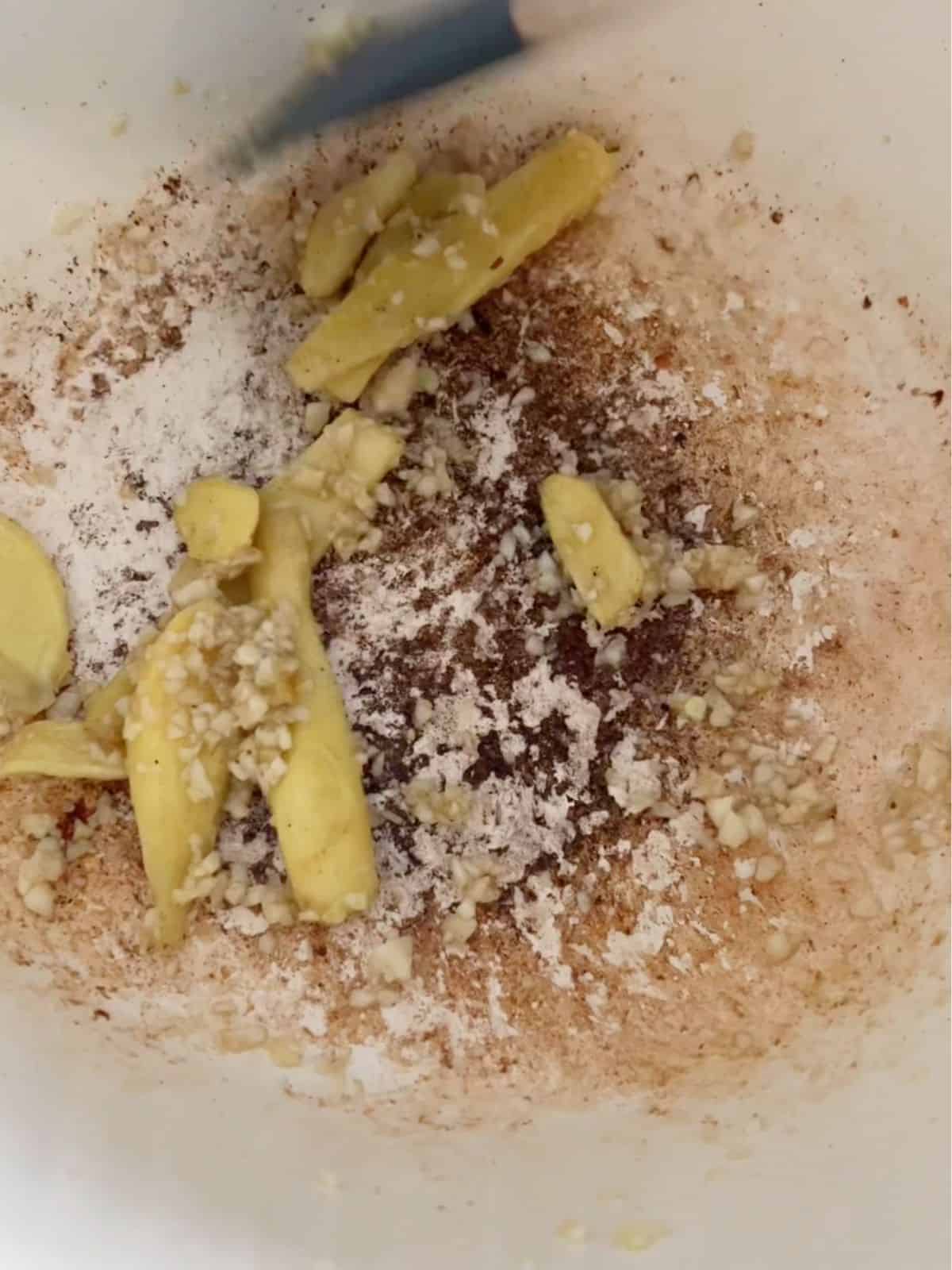 Garlic and ginger sautéing in a pot.