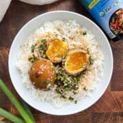 Overhead shot of mayak marinated eggs on a bed of rice with the marinade on top.