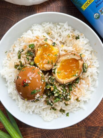 Overhead shot of mayak marinated eggs on a bed of rice with the marinade on top.