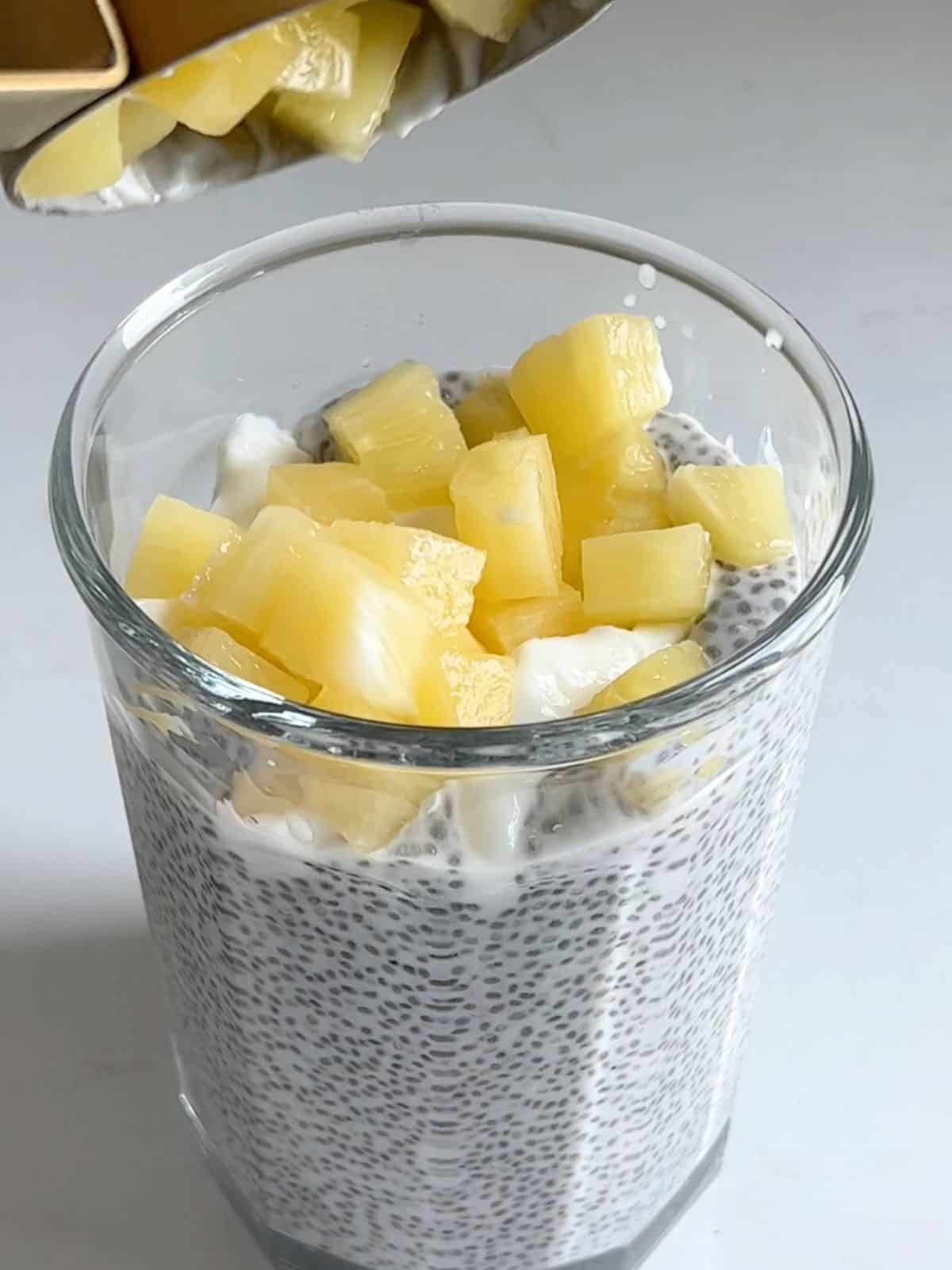 Mixing in pineapples and Greek yogurt into the chia pudding.