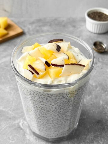 Pina colada chia pudding topped with fresh pineapple and coconut flakes.