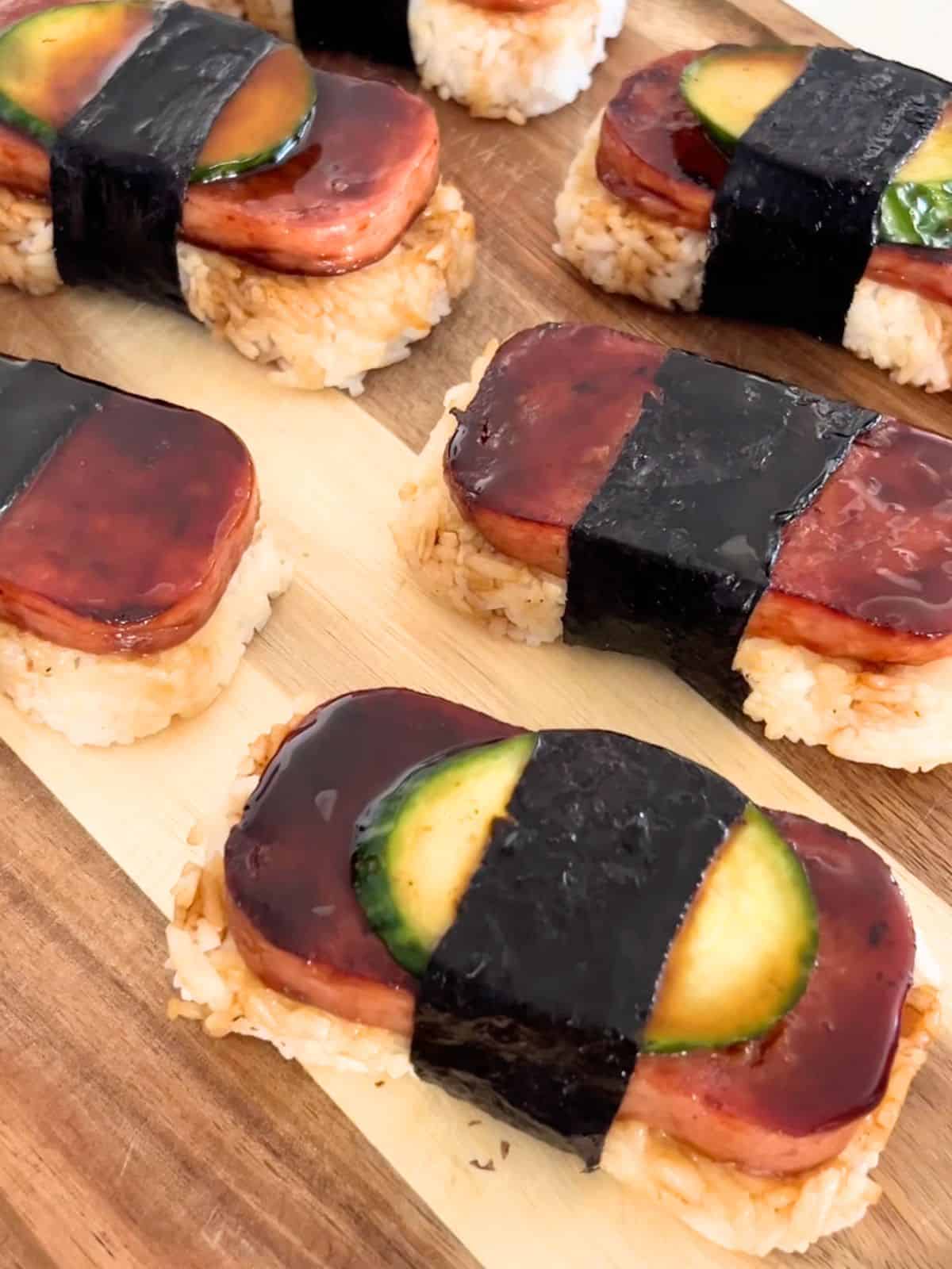 Assembled spam musubi on a wooden board.